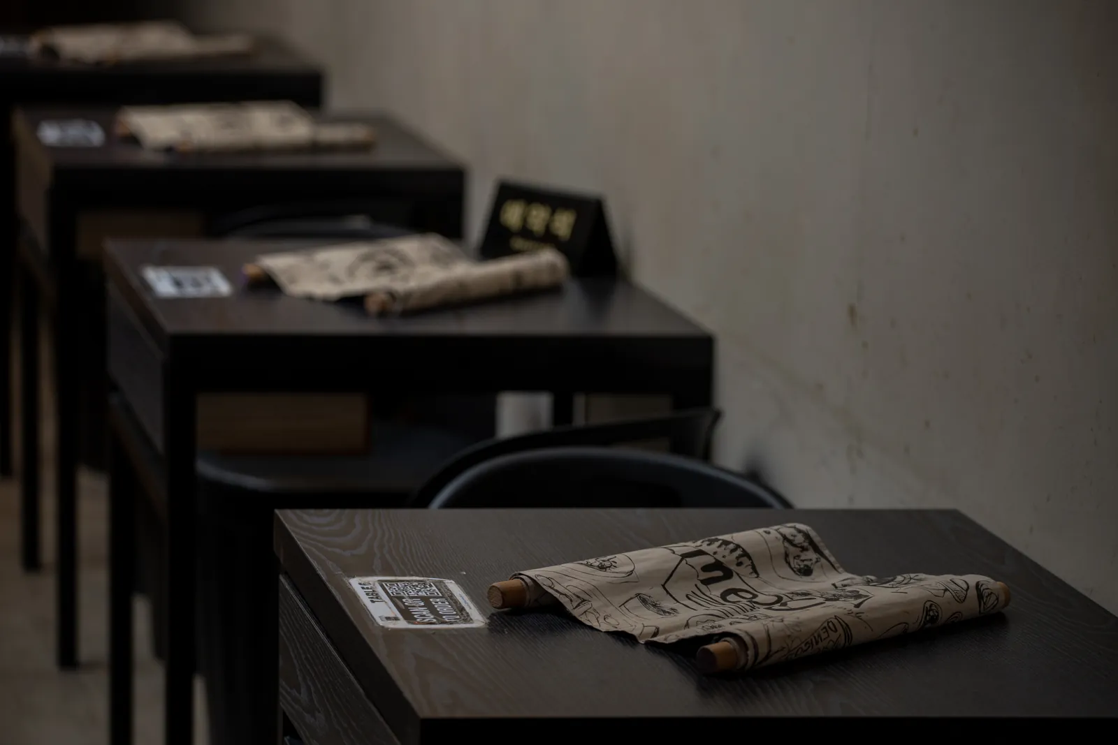 Hanok Shophouse: dark timber tables set with rolled paper menus