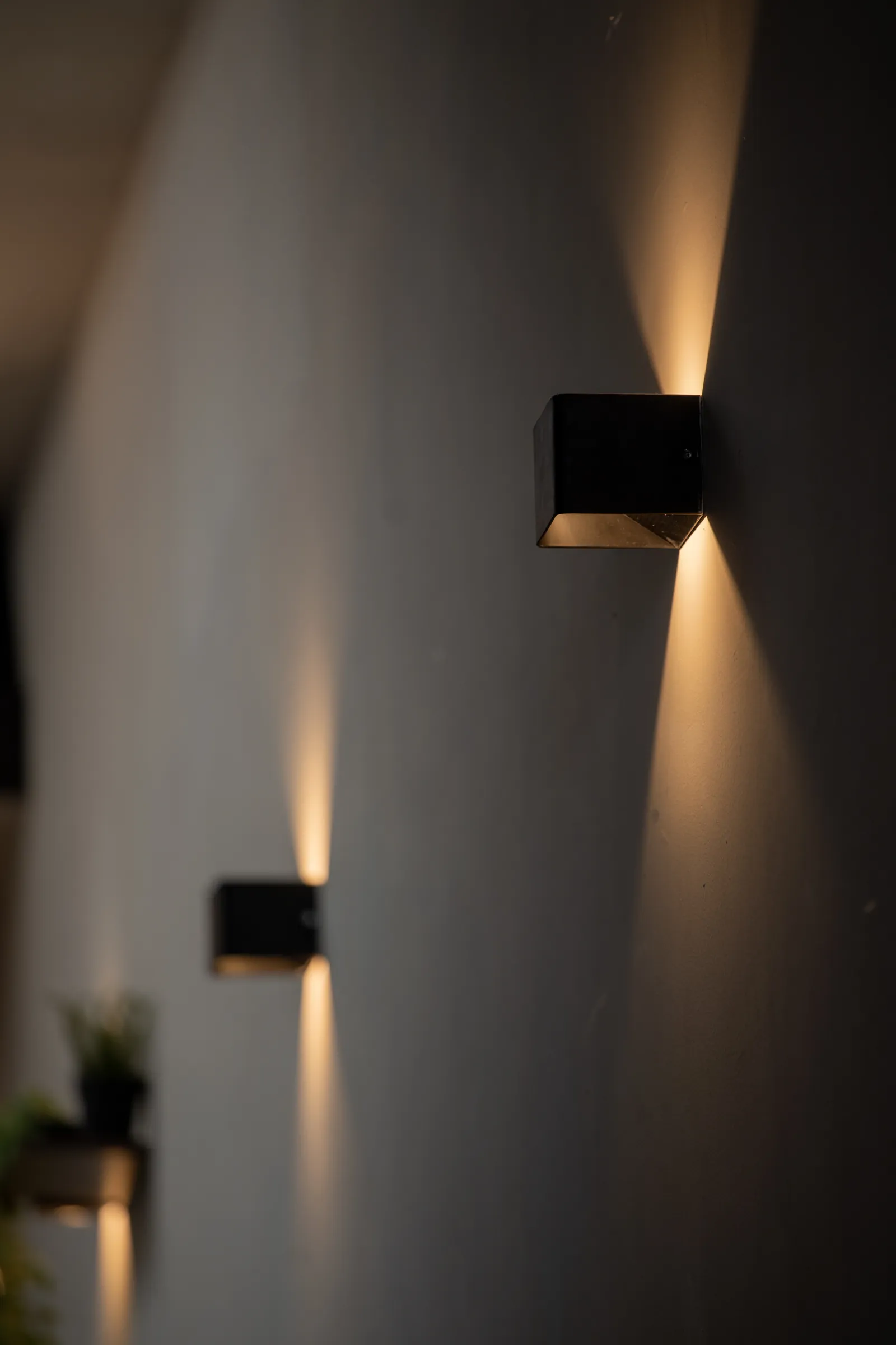 Hanok Shophouse: cube wall lights washing the plaster wall