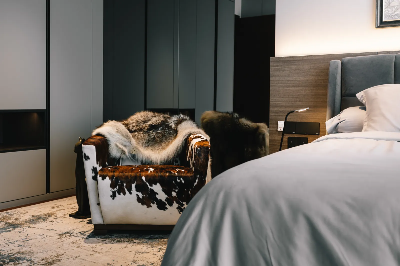 House of the Collector: bedroom with a cowhide armchair draped in fur