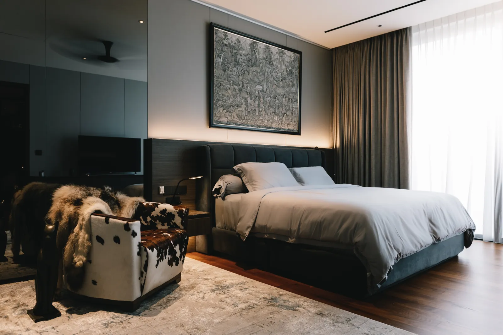 House of the Collector: bedroom with a large framed artwork above the bed and full-height curtains