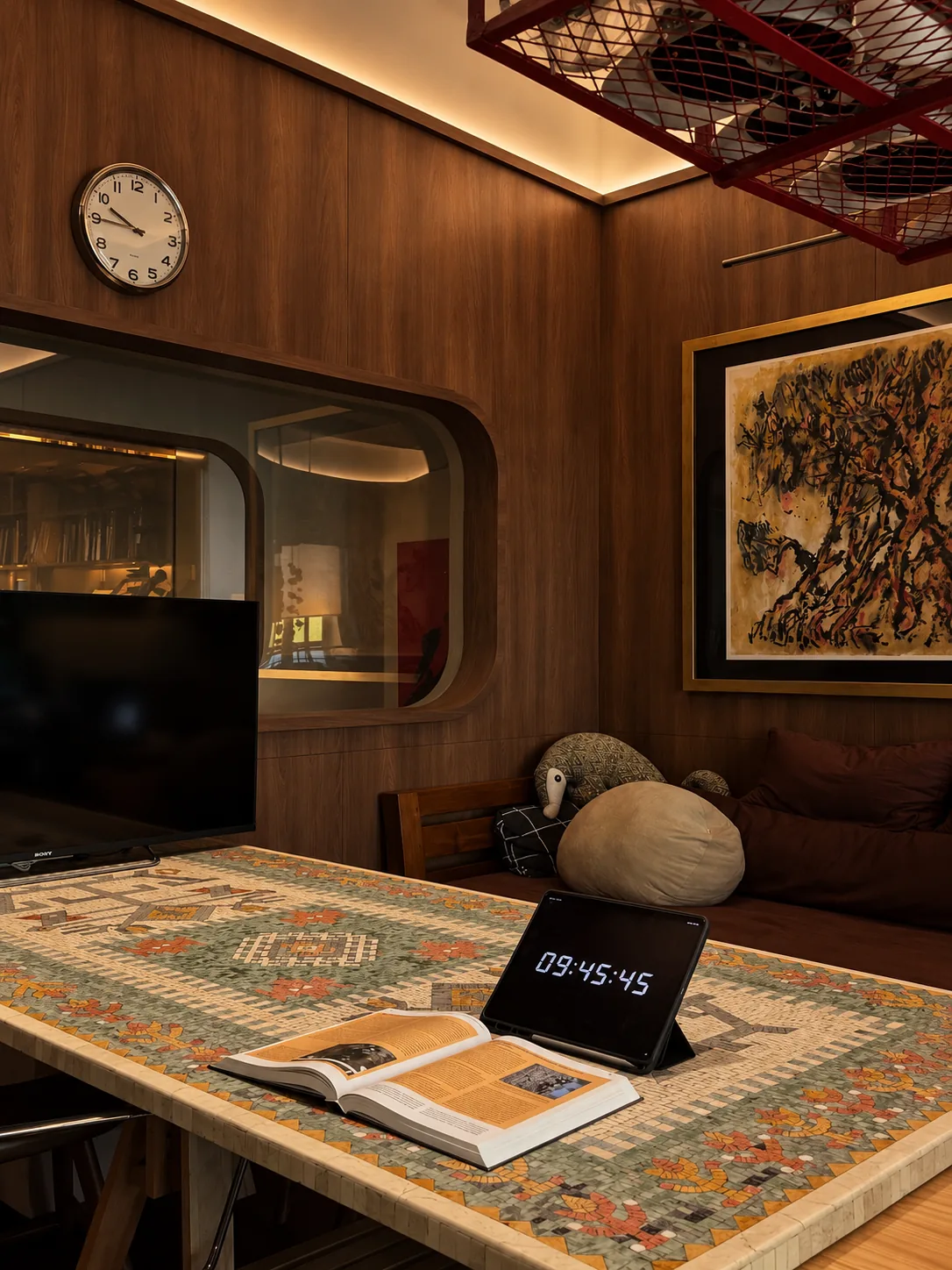 Library for the Arborist: an open book on the mosaic table, a rounded window to the next room and a painting of a tree