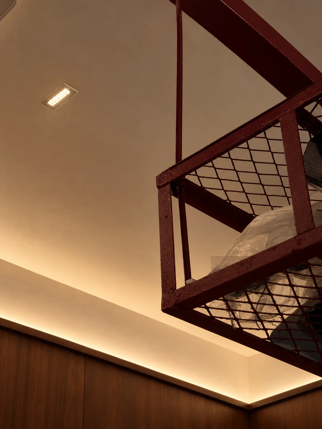 Library for the Arborist: the red steel mesh rack hung below a lit ceiling cove