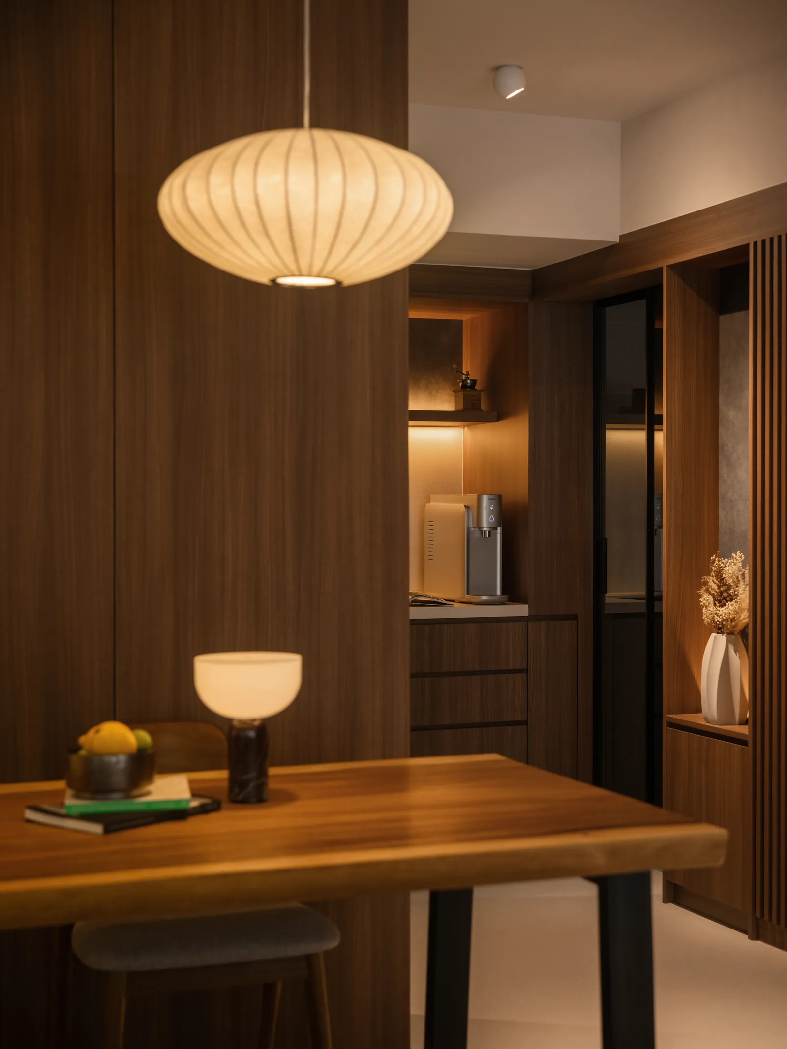 Mid Century Sanctuary: timber table under a paper lantern, with the kitchen beyond