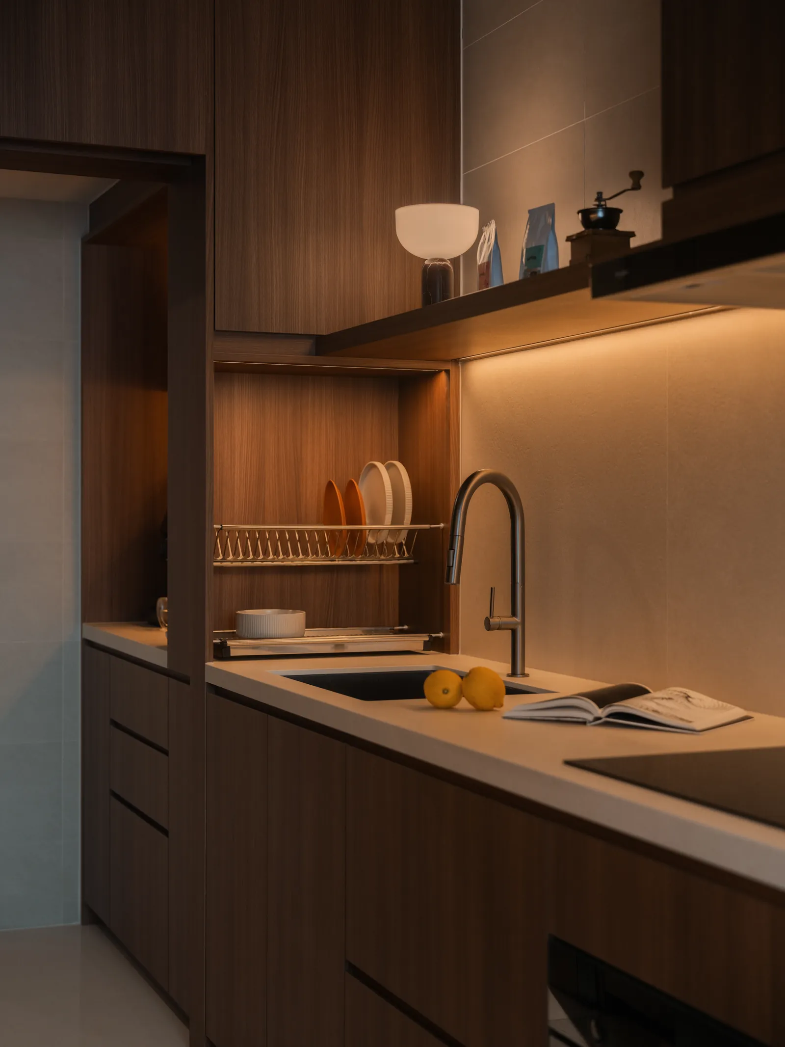 Mid Century Sanctuary: kitchen in timber and pale stone with a lit shelf and a dish rack