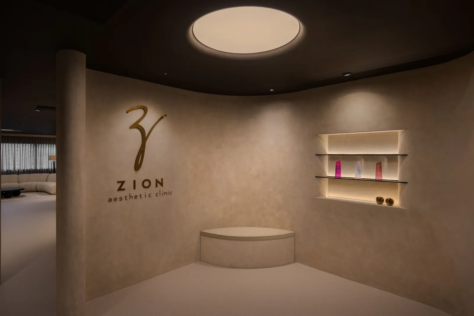 Rooms for Renewal: curved wall with the Zion logo, a lit display niche and a round ceiling light