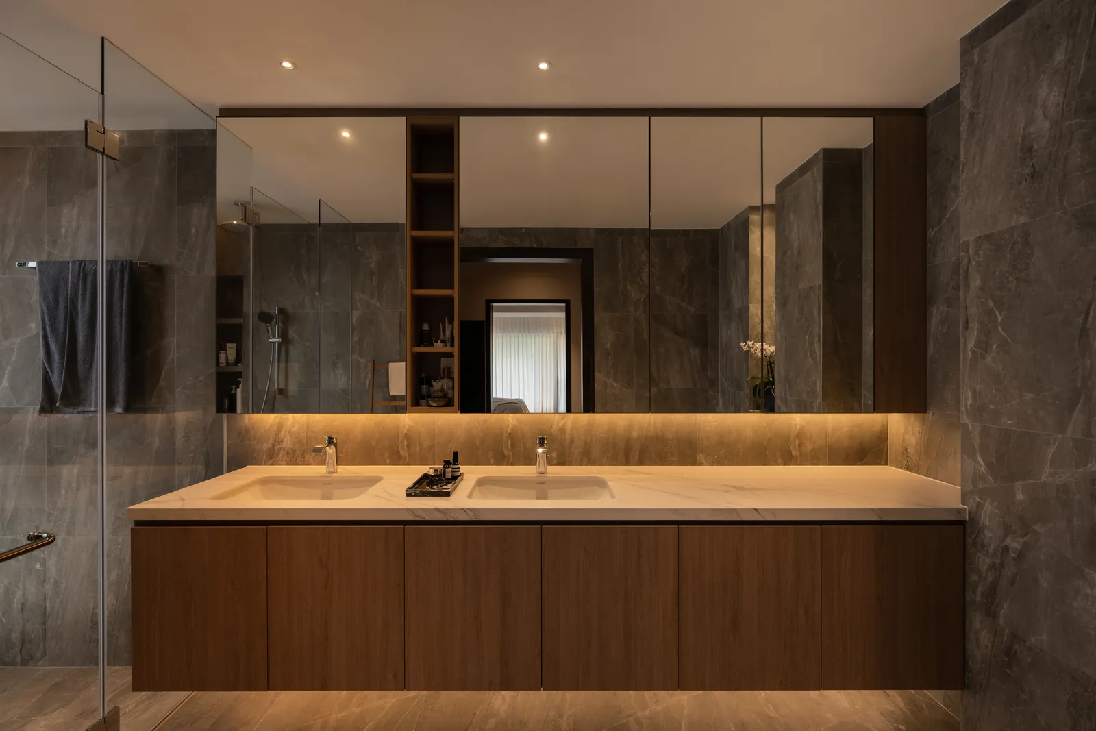 The Art of Retreat: double vanity in timber and grey stone, lit from below