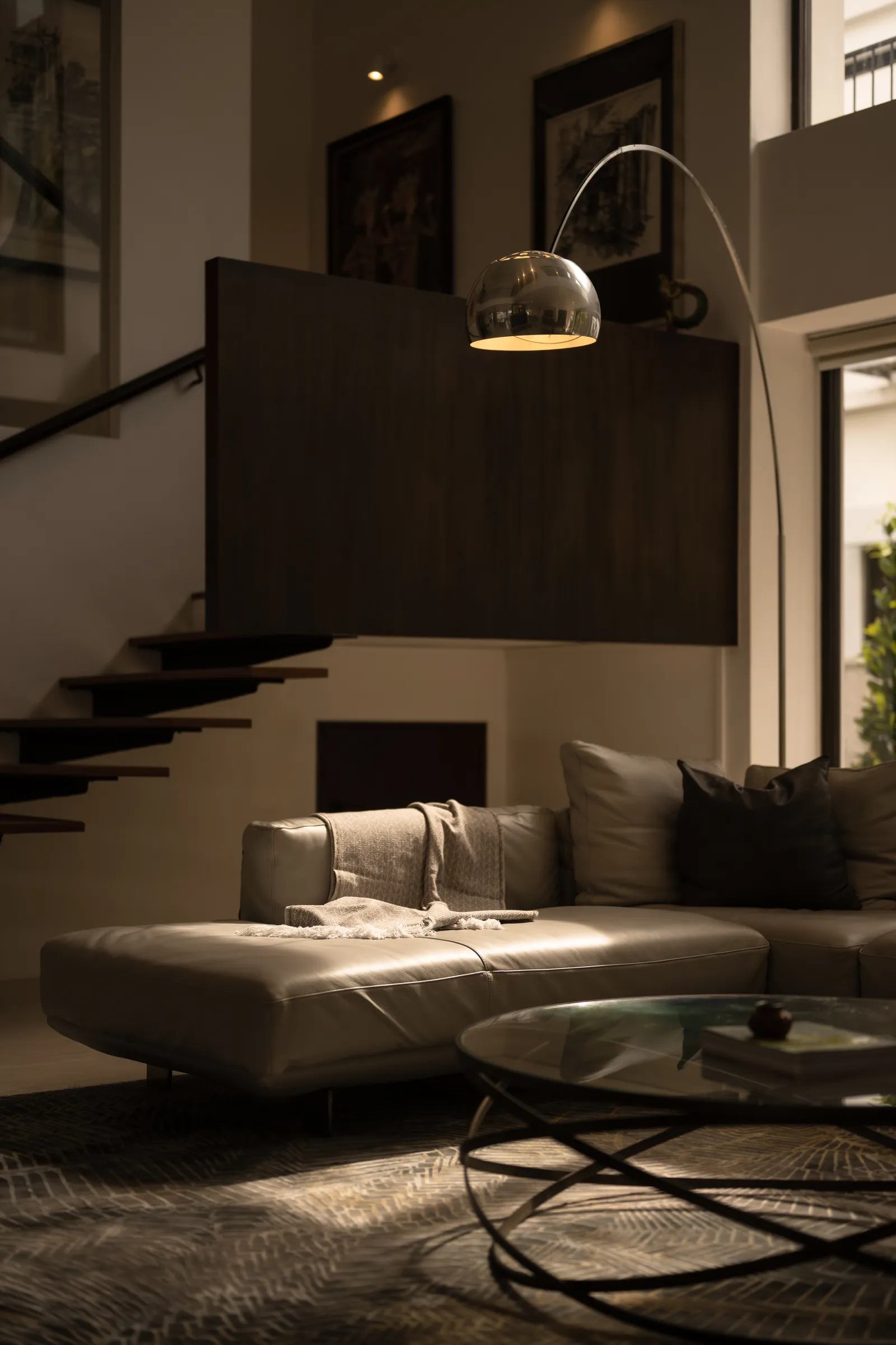The Art of Retreat: floating steel stair and an arc lamp over the lounge