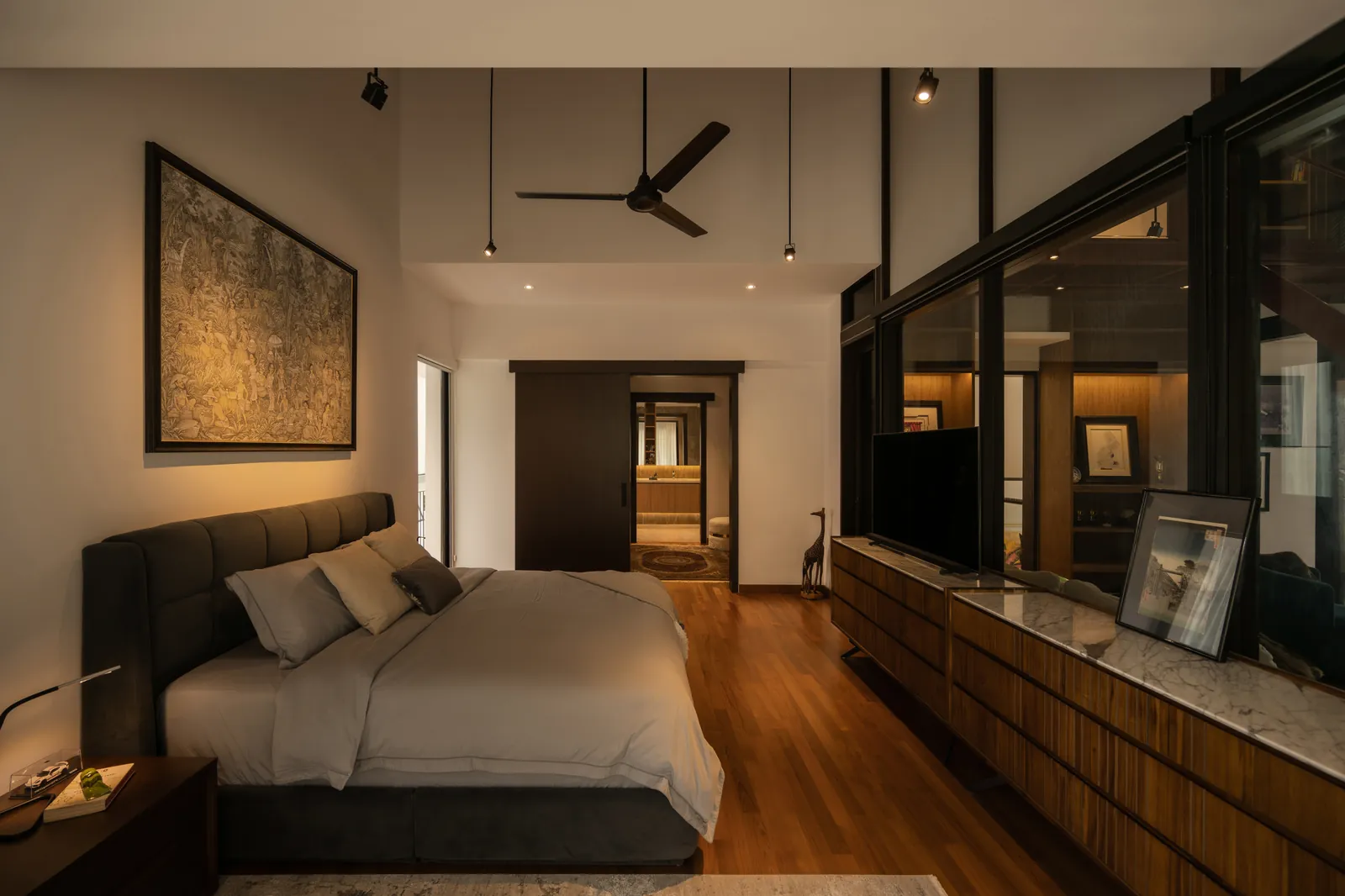The Art of Retreat: bedroom with a long timber cabinet, a ceiling fan and a large framed artwork