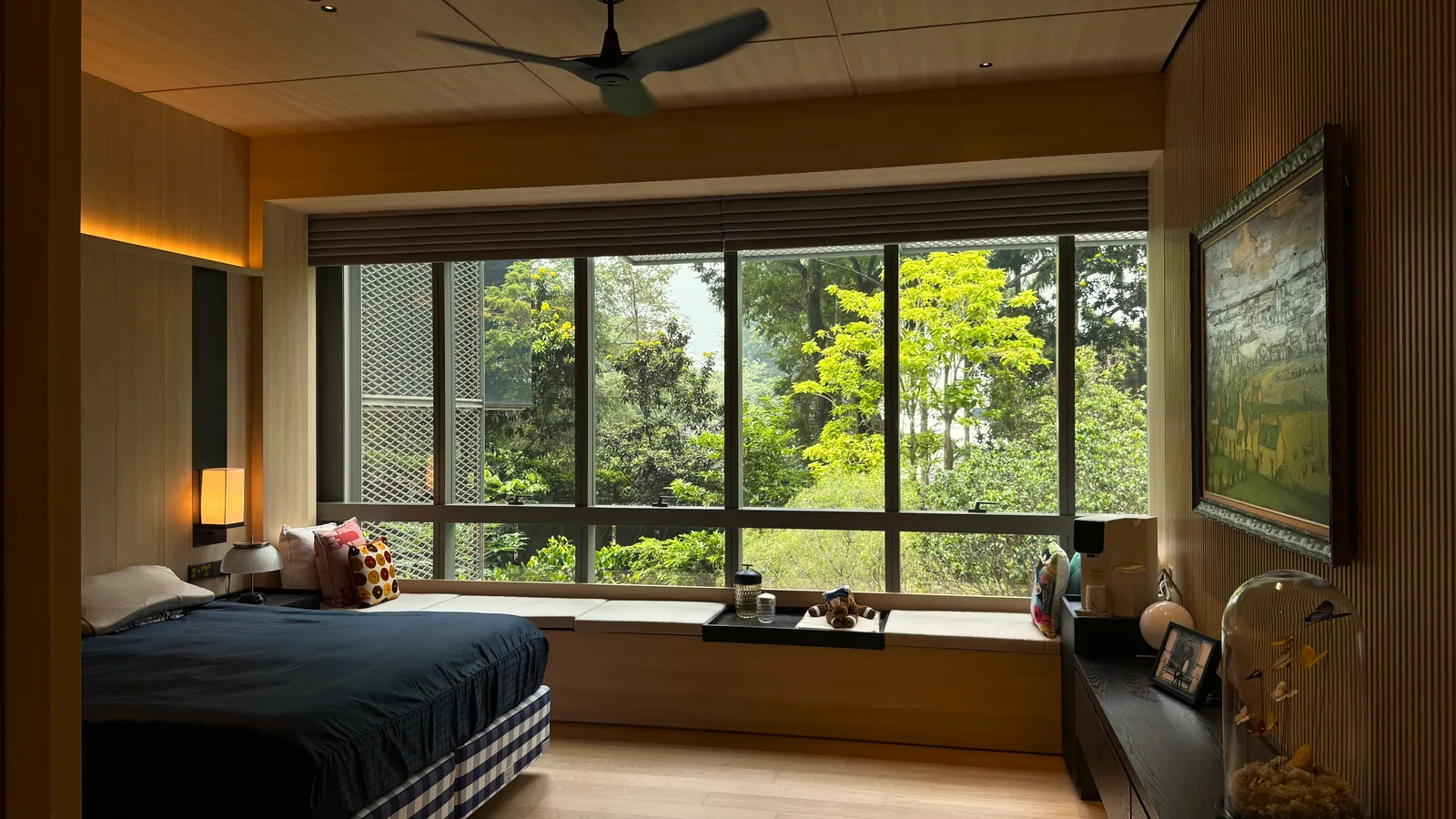 The Garden Within: timber-lined bedroom with a long window seat looking into the trees