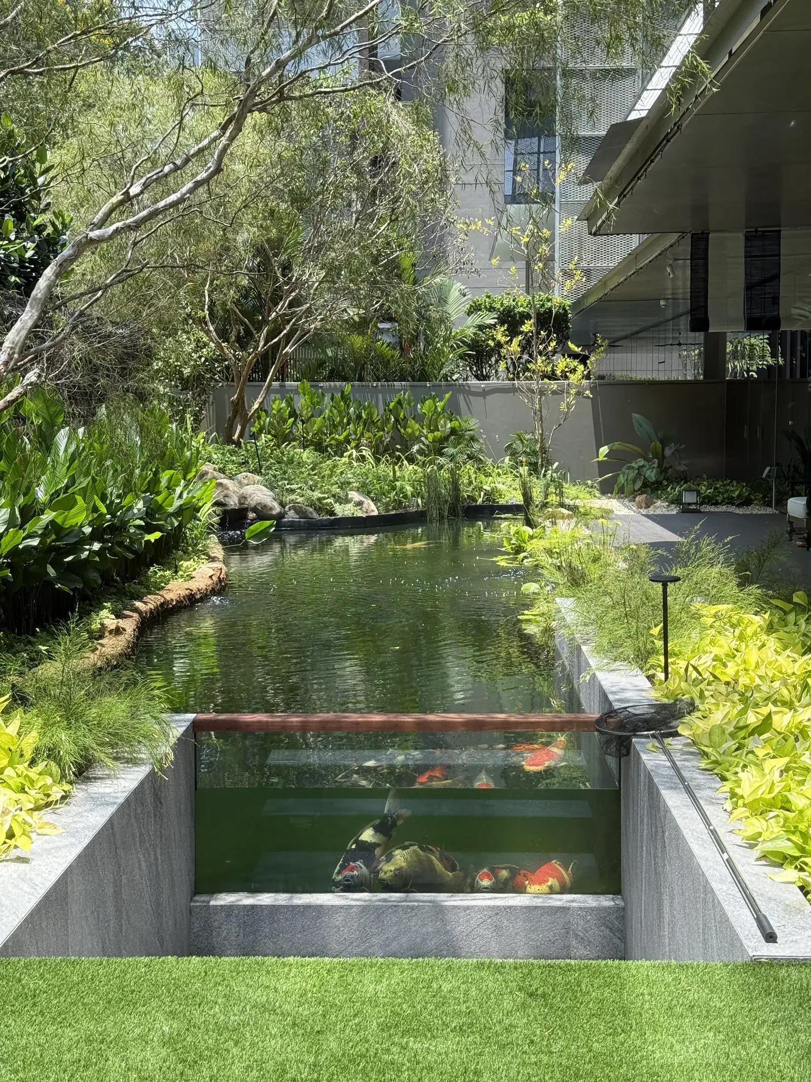 The Garden Within: a long koi canal ending in a glass viewing window