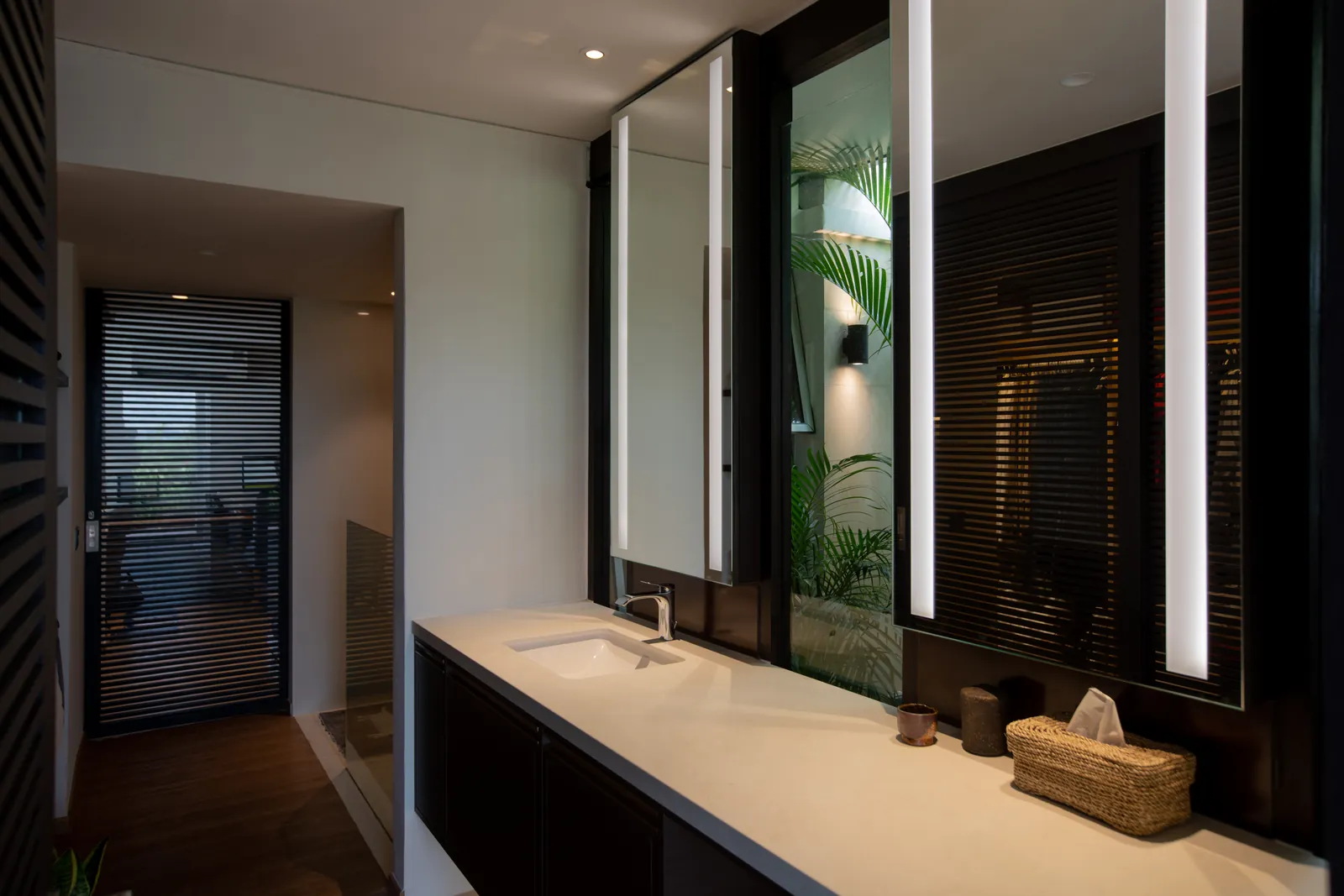 Villa in the Sky: vanity with tall lit mirrors and a view through to the bedroom